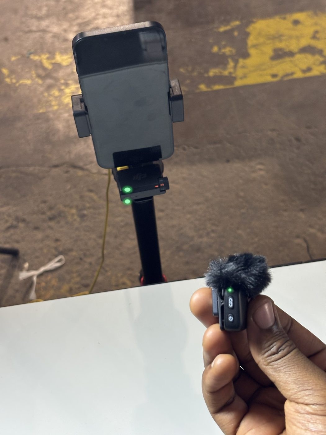 DJI wireless mic powered on — green lights lit on both the transmitter and the receiver before going live